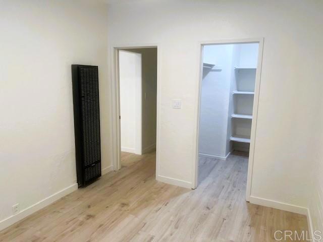 interior space with light hardwood / wood-style floors, a closet, and a walk in closet