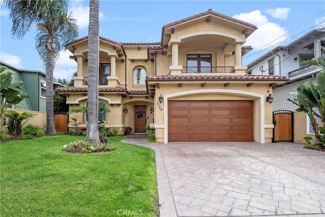 mediterranean / spanish house with a front yard, a garage, and a balcony