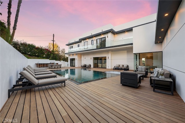 pool at dusk featuring an outdoor hangout area