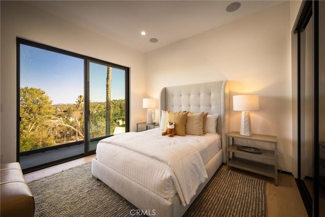 bedroom with access to exterior and dark hardwood / wood-style floors