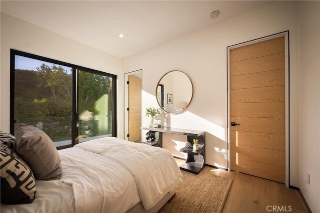 bedroom with access to outside and light hardwood / wood-style floors