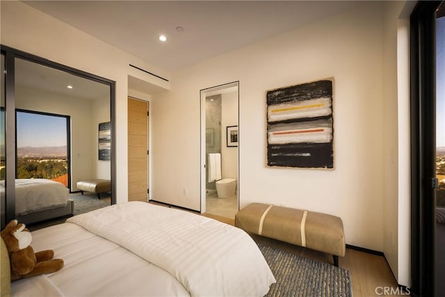 bedroom featuring ensuite bathroom, radiator heating unit, wood-type flooring, and access to outside