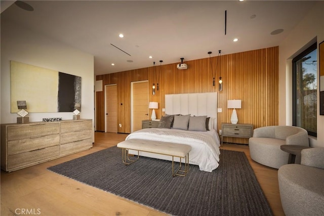 bedroom featuring hardwood / wood-style flooring and wood walls