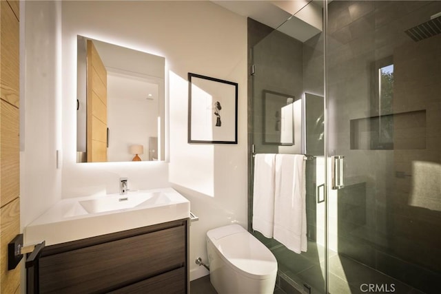 bathroom featuring vanity, an enclosed shower, and toilet