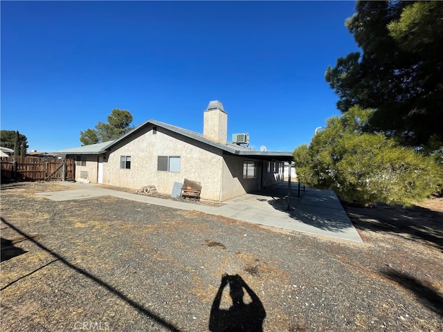 rear view of house with central air condition unit and a patio