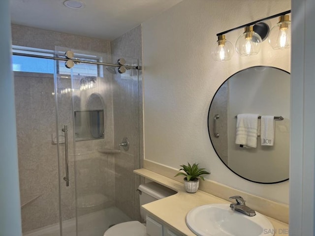 bathroom featuring toilet, an enclosed shower, and vanity