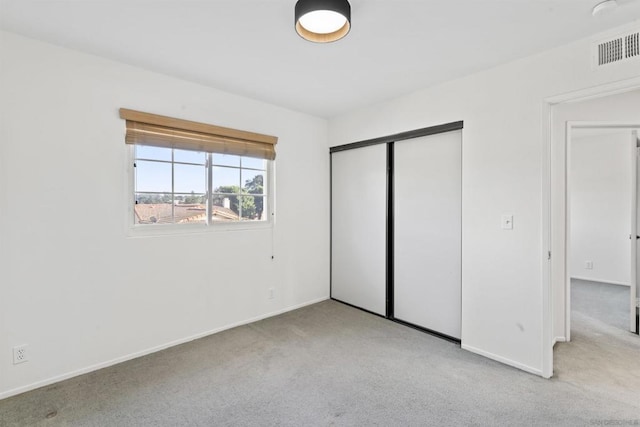 unfurnished bedroom featuring a closet and light carpet