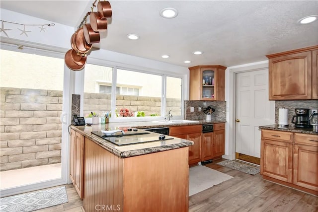 kitchen with decorative backsplash, sink, kitchen peninsula, and light wood-type flooring