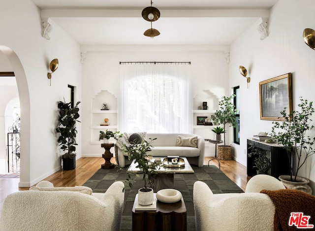 living room featuring built in shelves and light wood-type flooring