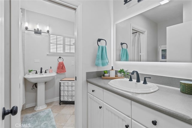 bathroom with dual sinks and tile patterned floors