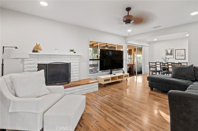 living room with light wood-type flooring and ceiling fan