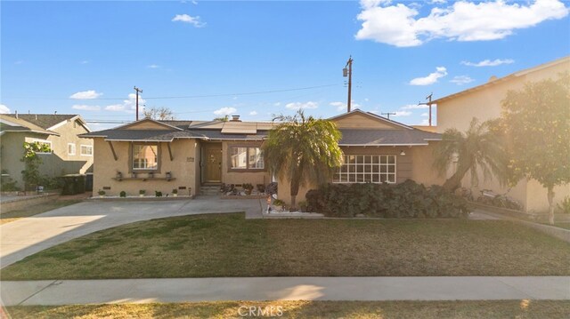 view of front of home featuring a front yard and solar panels