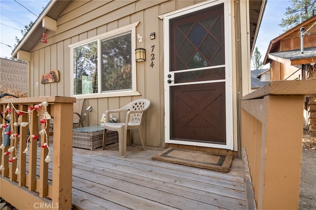 entrance to property with board and batten siding and a wooden deck