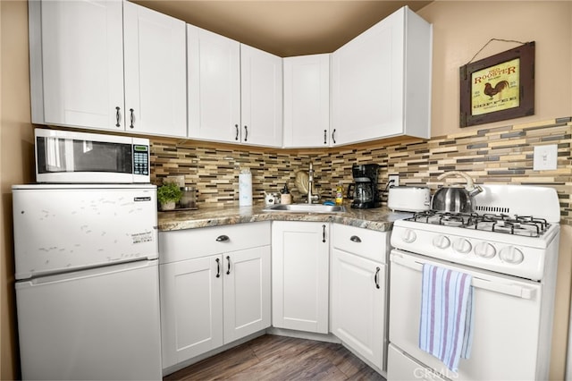 kitchen featuring white appliances, a sink, decorative backsplash, white cabinets, and light wood-type flooring