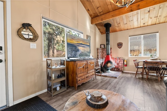 interior space featuring wooden ceiling, a wood stove, vaulted ceiling with beams, and wood finished floors