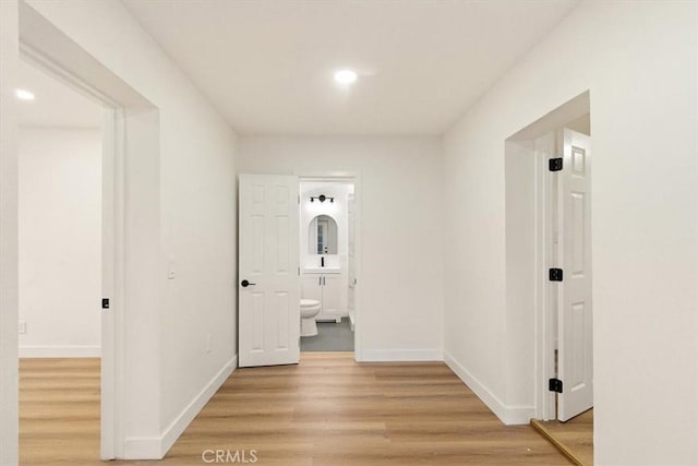 corridor featuring light hardwood / wood-style floors and sink