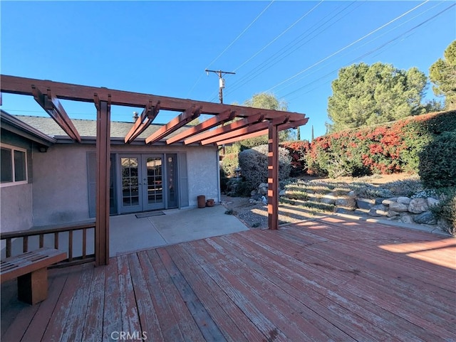 wooden deck with a pergola and french doors