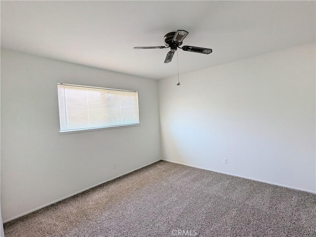 carpeted spare room featuring a ceiling fan