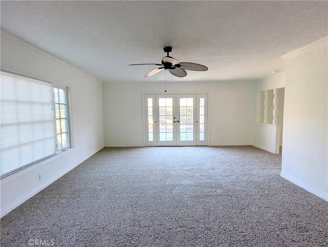 empty room featuring french doors, a textured ceiling, a healthy amount of sunlight, and carpet flooring