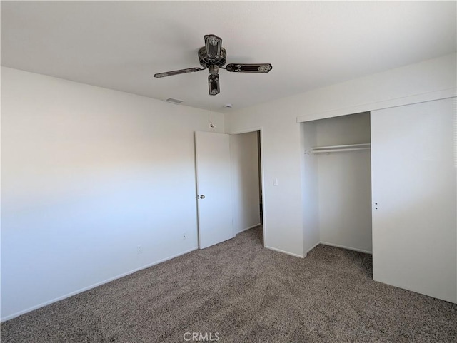 unfurnished bedroom with a closet, visible vents, ceiling fan, and carpet