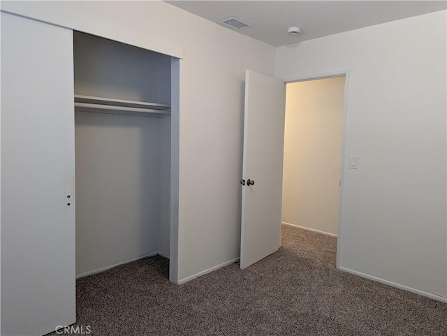 unfurnished bedroom featuring a closet, baseboards, visible vents, and carpet floors