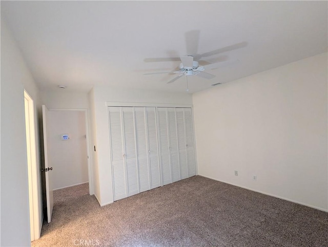 unfurnished bedroom with carpet, a closet, and ceiling fan