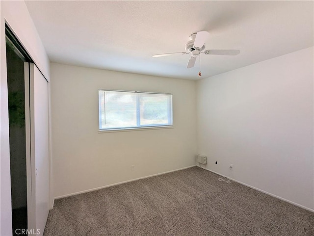 spare room with carpet flooring and a ceiling fan