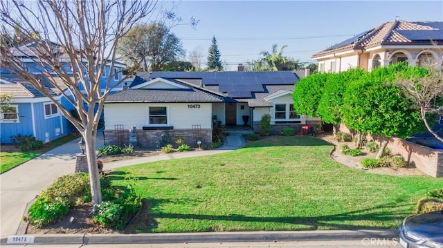 view of front of home with solar panels and a front lawn