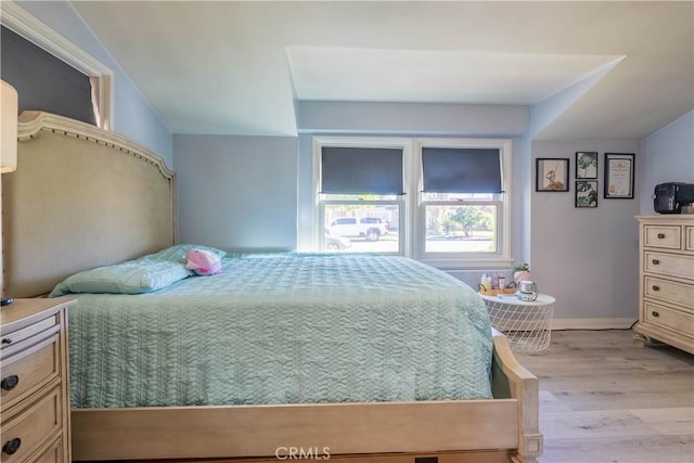 bedroom featuring vaulted ceiling and light hardwood / wood-style flooring