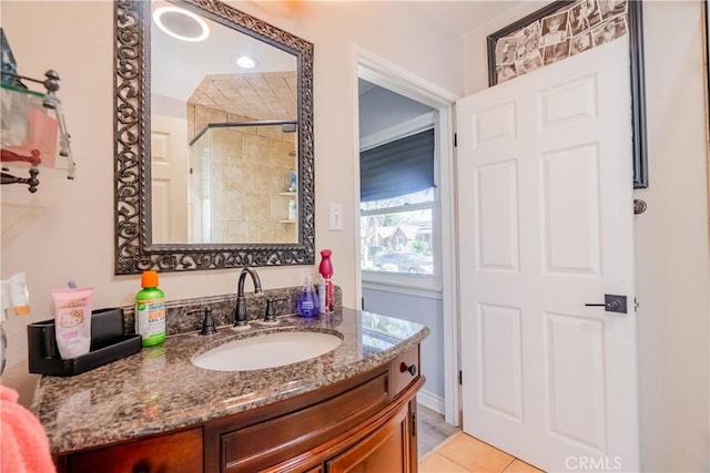 bathroom with a shower, vanity, and tile patterned floors