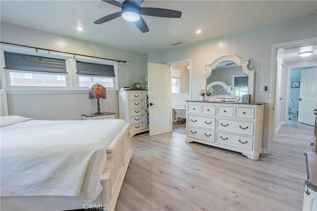 bedroom featuring ceiling fan, light hardwood / wood-style flooring, and connected bathroom