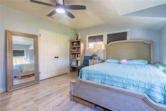 bedroom featuring ceiling fan, light hardwood / wood-style floors, a closet, and multiple windows