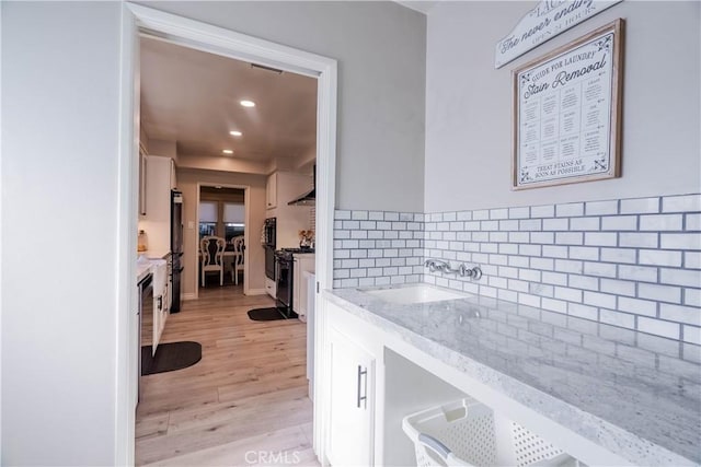 bathroom with vanity, hardwood / wood-style floors, and decorative backsplash