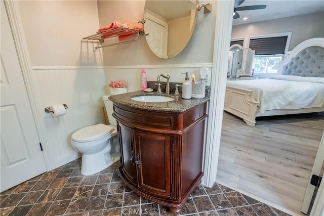 bathroom featuring toilet, vanity, ceiling fan, and hardwood / wood-style flooring