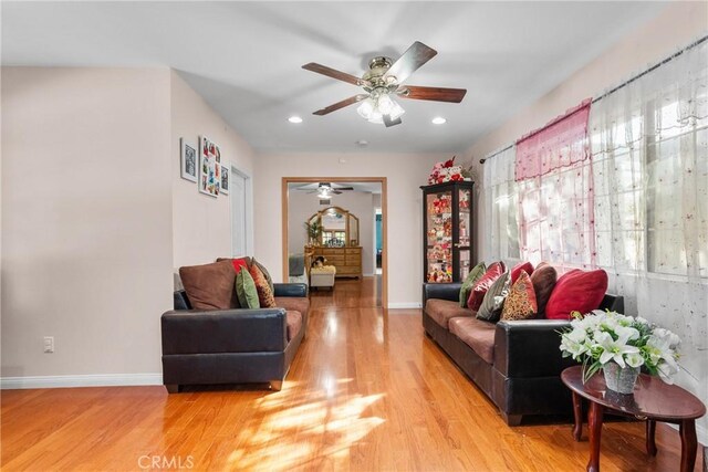 living room with ceiling fan and light hardwood / wood-style flooring