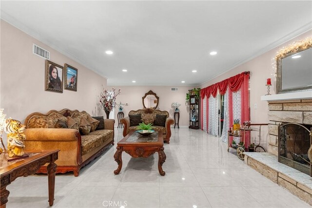 tiled living room with crown molding and a fireplace