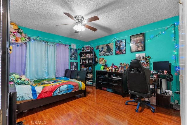 bedroom with hardwood / wood-style flooring, a textured ceiling, and ceiling fan