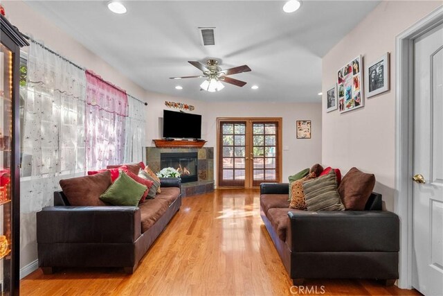 living room with french doors, ceiling fan, and light hardwood / wood-style flooring