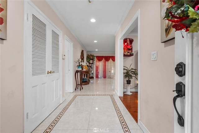 hallway featuring ornamental molding and light tile patterned floors