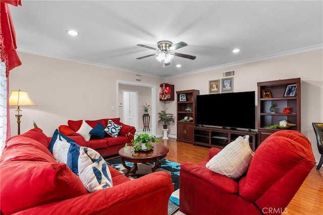 living room with hardwood / wood-style floors, ornamental molding, and ceiling fan