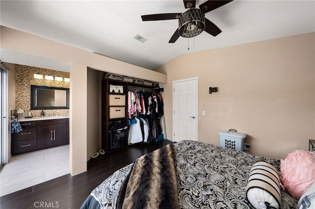 bedroom with sink, ensuite bath, vaulted ceiling, a closet, and ceiling fan