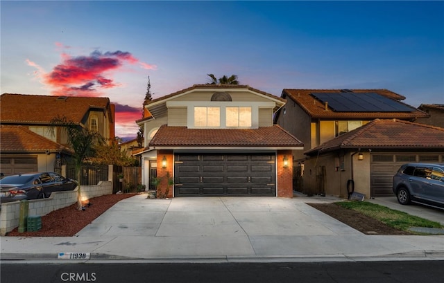 view of front of home with driveway, a tile roof, and solar panels