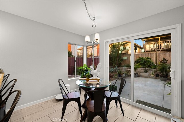 dining room featuring a notable chandelier and baseboards