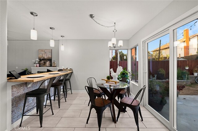 dining space with baseboards and a notable chandelier