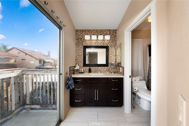 bathroom featuring backsplash, vanity, toilet, and tile patterned floors