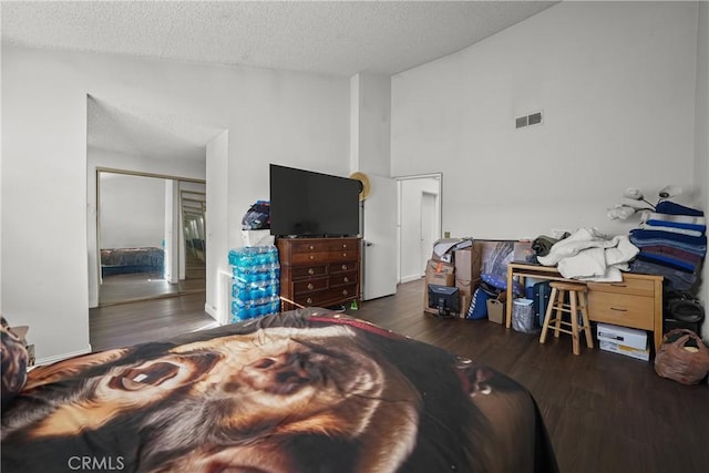 bedroom featuring a textured ceiling, dark hardwood / wood-style floors, a closet, and lofted ceiling