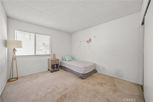 carpeted bedroom featuring a textured ceiling and a closet