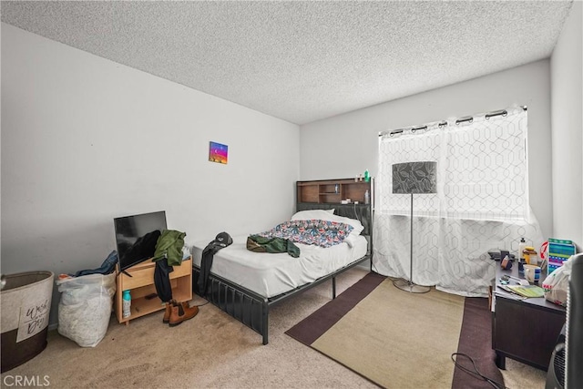 bedroom with a textured ceiling and light carpet