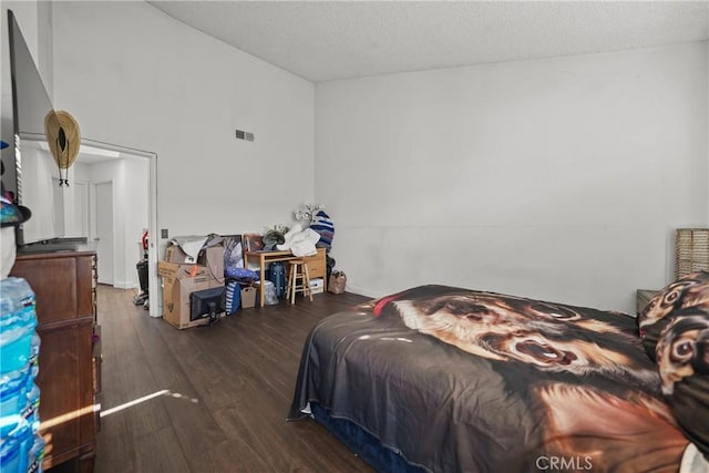 bedroom featuring a textured ceiling and dark hardwood / wood-style floors