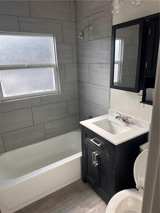 full bathroom with vanity, tiled shower / bath combo, and toilet